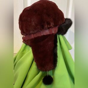 Stylish ushanka hat with a visor made of sheared mink with pom-poms